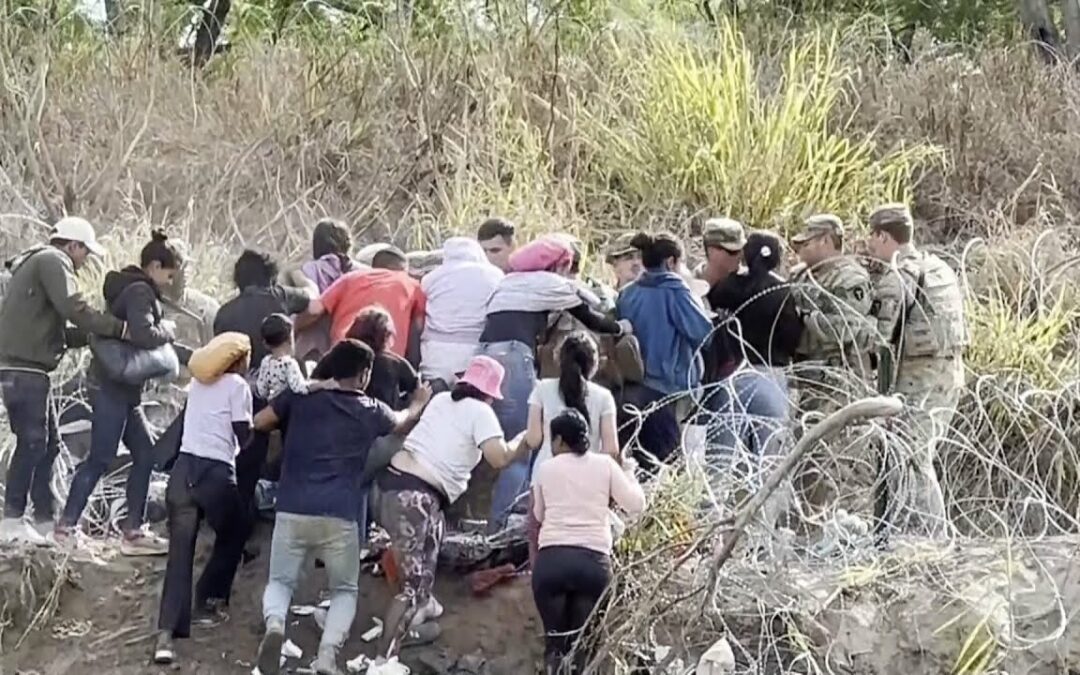 ¡A LA FUERZA! Migrantes derriban a agentes y cerco de púas en frontera de México-EE. UU.